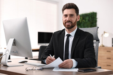 Obraz premium Man working with documents at table in office