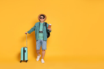 Traveller with passport and suitcase on yellow background. Space for text