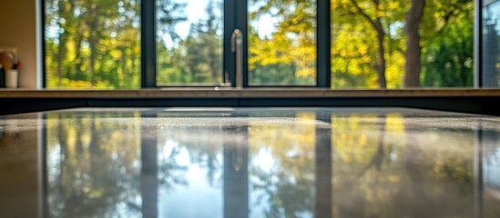 Naklejka premium Reflective Kitchen Countertop with Autumnal View