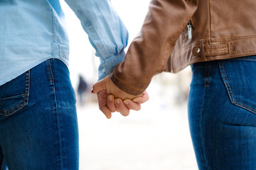  young couple holding hands while walking in the city