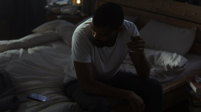 Stressed black man looks at ringing smartphone ignoring call