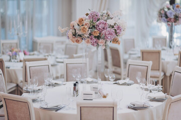 Beautiful Flower and candle decoration of wedding tables. Banquet table setting and decoration. Cutlery on the table. Tables set for an event party. Luxury elegant table setting dinner in a restaurant