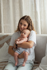 Happy teen gril with her cute adorable little infant sister holding in arms at cozy home. Sisterhood family and childhood concept