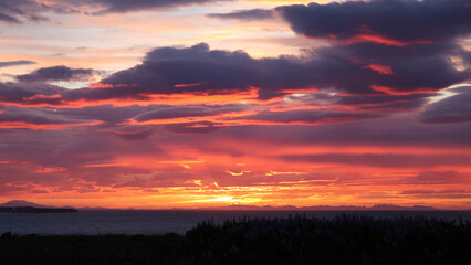 Sunset with vibrant colors in red orange and purple with dramatic clouds