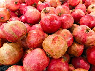Pomegranates on the market on the counter. Sale of fruits and berries. Background, pattern with fruits, berries, pomegranates. Group of pomegranates. Pomegranate background. Healthy food