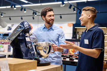 A customer discusses stand mixer features with a knowledgeable sales associate instore
