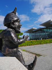 2024-07-08; sitting gnome against the background of the Wroclaw airport terminal Poland