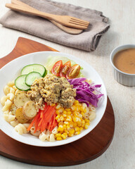 Fresh salad features pasta, colorful Salad, vegetables like cucumbers, tomatoes, and carrots, topped with a savory dressing, perfect for lunch