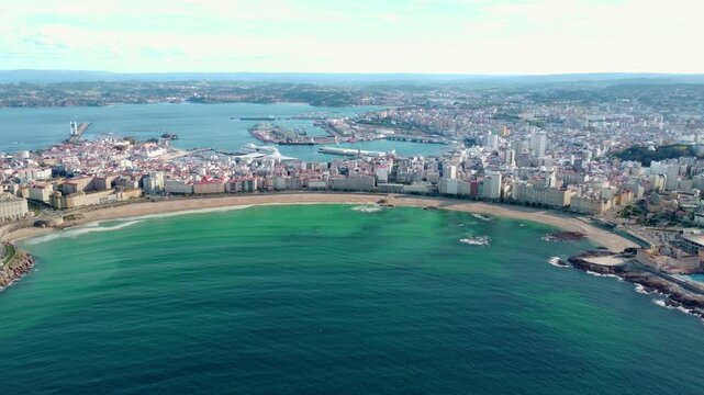 Beautiful panoramic aerial perspective of A Coruna city. Old historic center of the city and Port of A Coruna. Orzan Beach. Fanous travel destination in Galicia. Drone slowly descending above the bay.