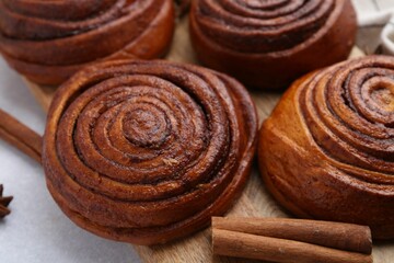 Delicious cinnamon roll buns on light table, closeup