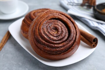 Delicious cinnamon rolls on grey table, closeup