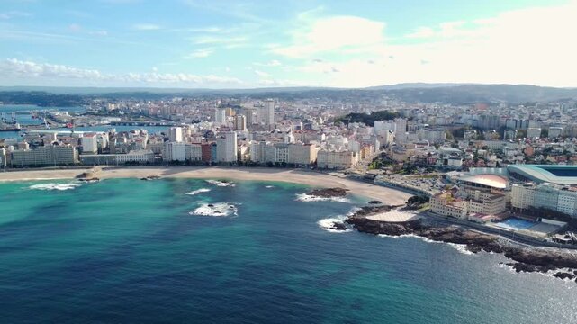 Panoramic aerial perspective of A Coruna city. Drone going backwards above the bay. Old historic center of the city. Orzan Beach. Riazor Stadium at right. Famous travel destination in Galicia.