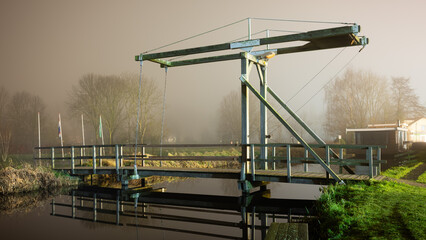 An old bridge over the lake in the fog