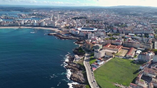 Panoramic aerial view of A Coruna city. View of Riazor Stadium in the middle. Famous travel destination in Galicia, Northwest of Spain. Drone going forward. Promenade and beach area of the city. 