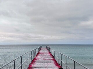 Obraz premium wooden red pier in the sea