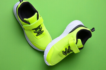 Light green sneakers on a bright background.