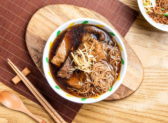 Angelica Vermicelli Rice Noodles Soup and Braised Tofu served in bowl with chopsticks and spoon on wooden board top view of taiwan food