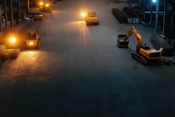 Heavy machinery operates at night in a spacious industrial warehouse