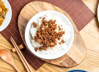 Ground Pork with Rice served in plate with chopsticks and spoon isolated on wooden board top view of taiwan food