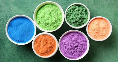 Bowls with different color powder pigments on green background