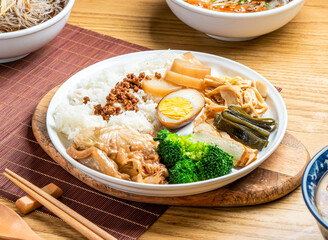 taiwanese lu rou fan include rice, broccoli, boiled egg, tofu, minced pork, braised pork belly, and cabbage served in plate with chopsticks and spoon isolated on wooden board side view of taiwan food