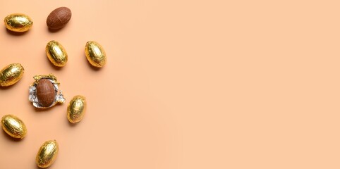Chocolate Easter eggs on beige background with space for text, top view