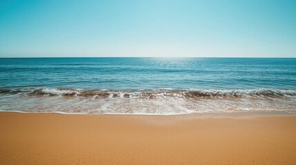 Obraz premium Serene Beach Landscape with Calm Ocean Waves and Clear Blue Sky