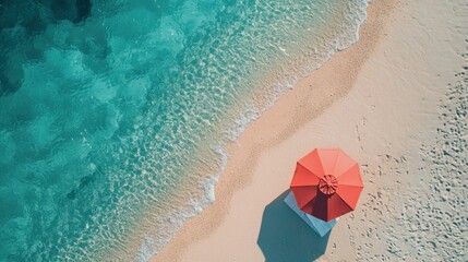 Naklejka premium Vibrant Red Umbrella on Sandy Beach with Clear Blue Water