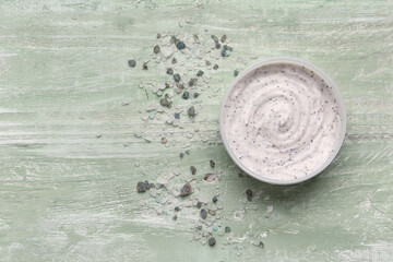 Jar of body scrub and sea salt on color wooden background