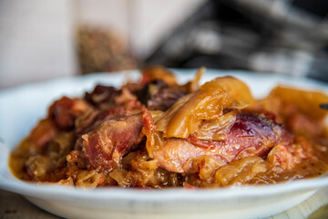 Boiled cabbage with meat on a wooden table