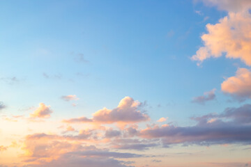 Blue sky with clouds illuminated by the setting sun. Beautiful skyscape