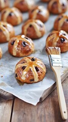 Hot Cross Buns with Glaze: Warm, freshly baked hot cross buns, glistening with a sweet glaze, arranged on a rustic wooden board. A pastry brush rests nearby, adding a touch of culinary artistry. 