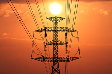 Power Lines Silhouette at Sunset: A stark silhouette of power lines against a fiery sunset sky...