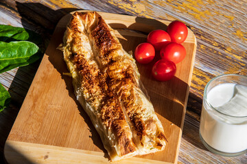 Pie with spinach on wooden background