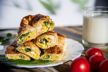 Pie with spinach on wooden background