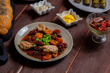 beans stewed with meat and dried fruits and sauce and hummus