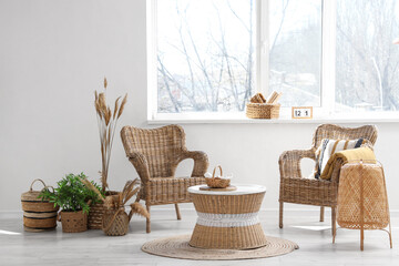 Interior of white living room with comfortable armchairs, coffee table and window