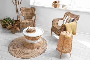 Fototapeta premium Cozy wicker furniture living room interior with natural decor, rattan chairs, coffee table, and jute rug