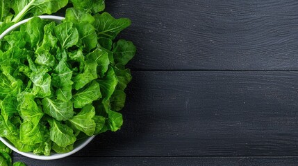 Fototapeta premium Fresh green lettuce in bowl, wood background, healthy food, recipe