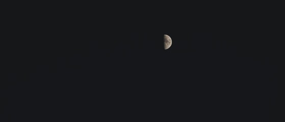 Minimalist half-moon against a dark sky
