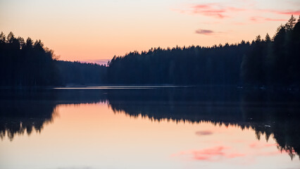 Lake scenery around sunset on a late spring evening in conifer forests of Finland