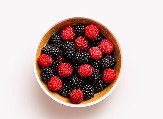 Fresh raspberries and blackberries in a bowl for a healthy snack or dessert option