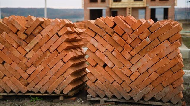 Stacks of red bricks on pallets at construction site