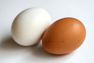 Two Chicken Eggs On A White Background One White, One Brown, 
