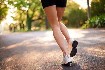 Running, legs and fitness with woman in road for marathon practice, workout and cardio. Wellness, exercise and sports training with closeup of person in nature for race, energy and athlete progress