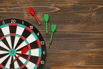 Dartboard with darts on wooden background
