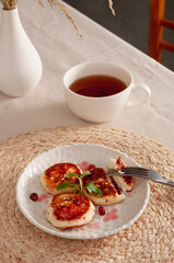 Fragrant fried tvorog pancakes with mint and pomegranate for the perfect breakfast.