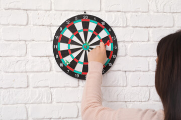 Young woman playing darts indoors