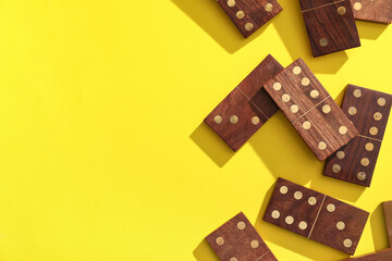 Wooden dominos blocks on yellow background