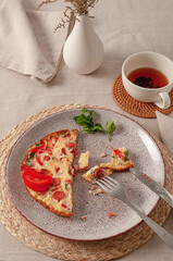 Fried omelette with tomatoes, sausages and fresh herbs for the perfect breakfast